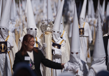 Penitents of "El Rocío" brotherhood with candles are seen walking along the street as they take part in a procession during the Holy Week in Malaga. The Holy Week in Andalusia is a on the most important and famous religious feast from Spain. Every year, thousands of christian believers celebrate the Holy Week of Easter with the crucifixion and resurrection of Jesus Christ.