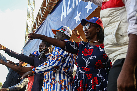 Azimio Coalition flag bearer Raila Odinga (C) speaks to his supporters. At the same time, his running mate Martha Karua (R) and other candidates point to their supporters during the political rally of Azimio la Umoja held at Nakuru hours after being approved by the Independent Electoral and Boundaries Commission (IEBC) to run for this year's presidential election. The Azimio la Umoja (Resolution of Unity) Presidential candidate Raila Odinga and his running mate, deputy presidential candidate Martha Karua, and other team leaders attended a political rally after being approved by the Independent Electoral and Boundaries Commission (I.E.B.C) for upcoming elections in August.