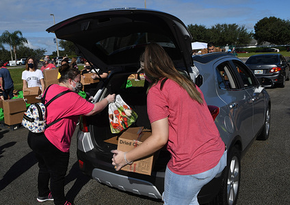 Volunteers distribute turkeys and other food assistance to the needy at a food distribution site at Lake-Sumter State College sponsored by the Second Harvest Food Bank of Central Florida and local churches.
With the approach of Thanksgiving, thousands of families in the Orlando area are in need of food assistance due to COVID-19 related layoffs in the tourist industry and the expiration of supplemental federal unemployment benefits.