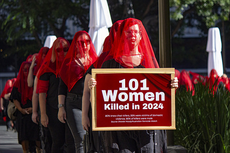 Protestors follow behind a person holding a sign saying "101 Women killed in 2024". Protesters held a silent march for the 101 Women killed in Australia in 2024.