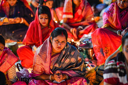 A Hindu devotee sits with Prodip and prays to God in front of Shri Shri Lokanath Brahmachari Ashram temple during the religious festival Kartik Brati or Rakher Upobash in Dhaka.