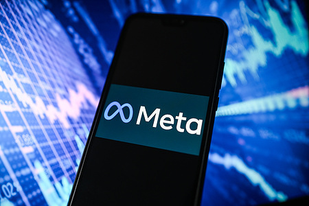 In this photo illustration, a Meta logo is displayed on a smartphone with shows graphs in the background.