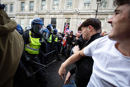 A Unite The Kingdom supporter retreats after being hit on the head with a police baton. Scuffles broke out after Tommy Robinson's Unite The Kingdom march finished and police decided to move attendees away from the rally. A counter-demonstration was also organised by Stand Up To Racism, which saw 16000 police officers deployed to keep the peace. Up to 150,000 people are believed to have joined the march.