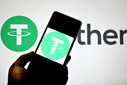 In this photo illustration, a Tether logo is seen displayed on a smartphone and in the background.