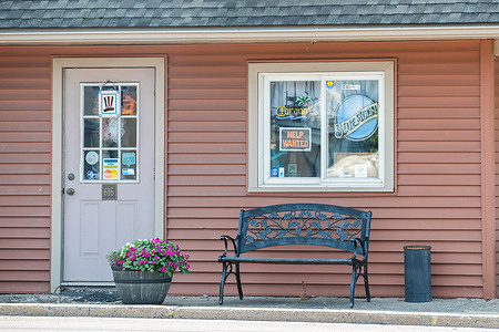 A now hiring sign is seen in the window of LT Evans Eatery and drafthouse.