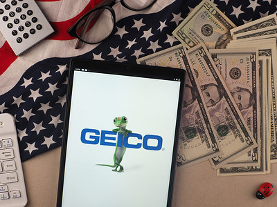 In this photo illustration, Government Employees Insurance Company (GEICO) logo seen displayed on a tablet.