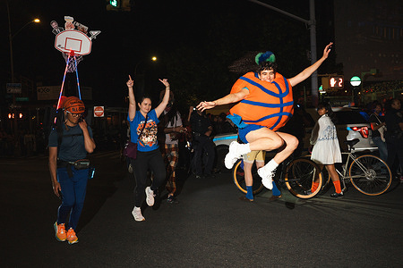 A woman, wearing a giant basketball costume, jumps and cheers during an NBA Finals Game 3 watch party in the Brooklyn borough of New York City. Fans of the New York Knicks hosted a watch party for the NBA Finals Game 3 in the Brooklyn borough of New York City.