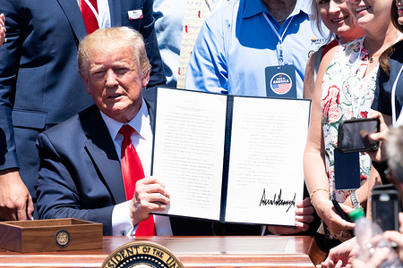 President Donald Trump signing an Executive Order on maximizing use of American goods, products and materials at the 3rd Annual Made in America Product Showcase near the South Lawn of the White House in Washington, DC.