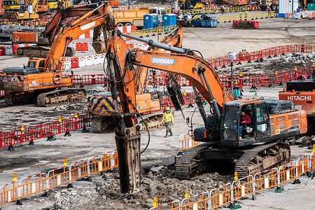 Construction vehicles prepare the foundation for the Kai Tak Cruise Terminal quarantine construction site. 
New community quarantine centres are being built across Hong Kong to accommodate the growing number of people testing positive for COVID-19. With a policy to isolate, treat, and, if needed, hospitalize all COVID-19 patients as well as close contacts, the Hong Kong government is creating upwards of 10,000 new spaces for isolation and treatment.
