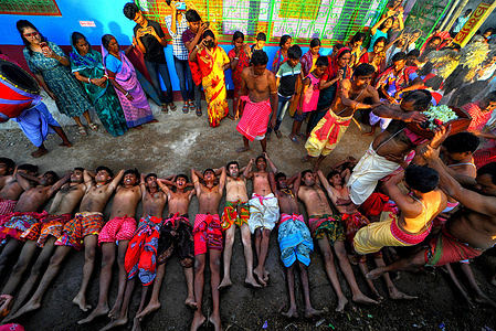Hindu devotees seen lying on the ground during the ritual time of Gajan Festival. Gajan is a Hindu festival celebrated mostly in the rural part of West Bengal. The festival is related to Lord Shiva and as per Mythology on the last day of Bengali Calendar (Middle of April) devotees used to worship dead bodies to satisfy Lord Shiva for better rain and harvest. The central theme of this festival is deriving satisfaction through non-sexual pain, devotion and sacrifice.