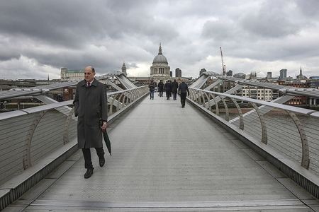A man is seen crossing the London Millennium Footbridge, a steel suspension bridge for pedestrians spanning Thames River in London. The bridge is nicknamed the "Wobbly Bridge" because of the swaying effect. The bridge was opened in June 2000.