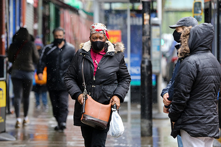 Members of public are caught during rainfall in London.