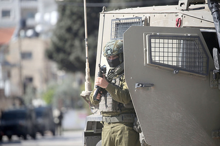 An Israeli soldier takes up position around Joseph's Tomb during a visit by religious Jews. Dozens of religious Jews illegally entered the site which is under Palestinian security control. Israeli forces then entered the area to secure their exit.