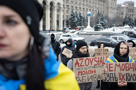 Relatives of Ukrainian soldiers who were captured by Russia holding signs urging the authorities to bring their loved ones back from Russian captivity during a rally.