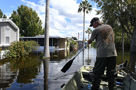 Kit Brown paddles his boat in a flooded street near his home in the Jade Isle Mobile Home Park in St. Cloud. Residents of the community were issued a voluntary evacuation order due to rising water levels in the aftermath of Hurricane Ian.