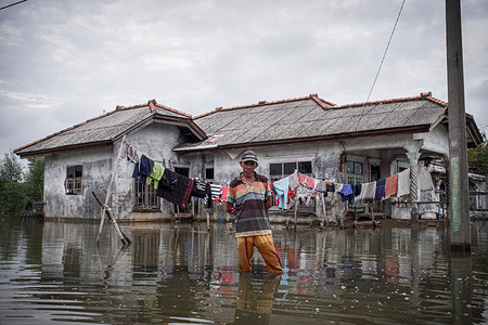 Tebe (63), a fisherman stands in a flooded area in Muara Gembong Village. Based on the Climate Central report, a number of areas in the West Java Coastal Coast are predicted to sink in the next eight years. The threat can also be seen through the Climate Central map regarding the distribution of areas that will sink in 2030. Based on the Climate Central map, the areas predicted to sink are spread from Bekasi, Karawang, Subang, and Indramayu to Cirebon. The threat to the Coastal Coast of West Java was mentioned by the Governor of West Java, Ridwan Kamil who declared that 200 hectares of land in Bekasi Regency have been lost due to rising sea levels.