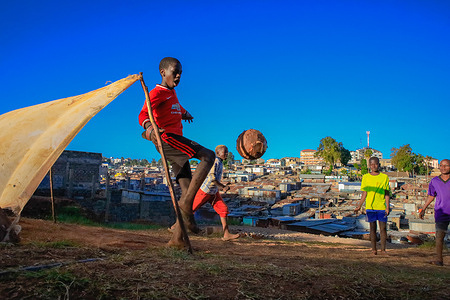 Kids play soccer by the neighborhoods in Kibera Slum. Kibera Slums is viewed as the biggest, largest and poorest slum in Africa. The most discussed suburb of Nairobi and its extremely continuous population and slow economic growth is one of the most underserviced settlements in Kenya.