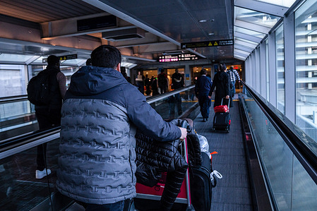 A man with luggage walks on a moving walkway at the YYZ Toronto Pearson International Airport.
(YYZ is the IATA airport code for Toronto Pearson International Airport) Canadian travel has faced a series of disruptions over the past winter, leading to critiques from passengers and the government alike. House transport committee hearings started to dig into why this holiday's travel season descended into chaos for many travelers.