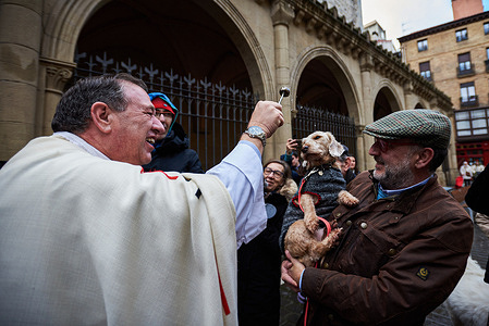 A pet is blessed by the parish priest Cesar Magaña outside the Church of San Nicolás in Pamplona to celebrate the day of San Antón, the patron saint of animals.