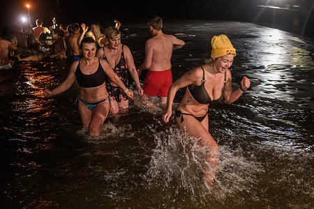 People bathe in the icy water of Balsys lake shortly after midnight during a traditional Epiphany celebration on the outskirts of Vilnius. Water on Epiphany is considered holy and believed to have special powers of protection and healing.