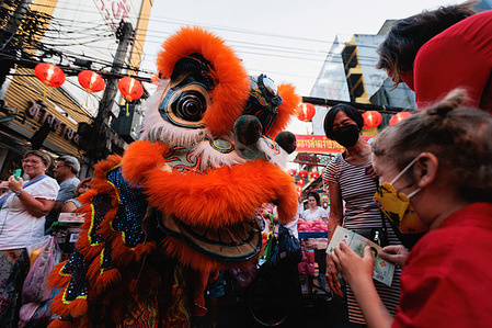 Child seen giving money to a lion dance performer on Yaowarat road during the Lunar New Year celebration. After two years under strict Covid-restrictions, Bangkok's Chinatown finally gets to celebrate the 2023 Lunar New Year.