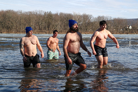 People take part in the 19th annual Lewisburg Polar Bear Plunge. Participants waded into the icy waters of the West Branch of the Susquehanna River as the air temperature was 23 degrees fahrenheit (minus 5 celcius).