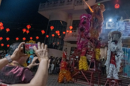 A spectator records the lion dance at the Cap Go Meh 2023 festival at the Eka Dharma Manggala Kendari Temple. The Cap Go Meh Festival is held simultaneously in various region of Indonesia, including the city of Kendari. The Festival, which is held two weeks after the Chinese new year, is closing series of Chinese New Year celebrations.