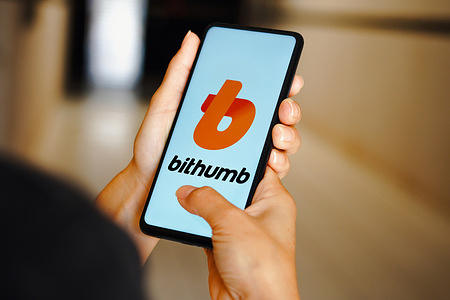 In this photo illustration, the Bithumb logo is seen displayed on a smartphone.