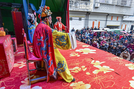 Actors are performing "ZhaGuoHuai", a traditional Chinese opera, and the audience is watching it carefully in the countryside. The 2nd day of the 2nd month of the Chinese lunar calendar is called the day of "Dragon raising its head". Traditional folk performances are held in some parts of China to celebrate this day.