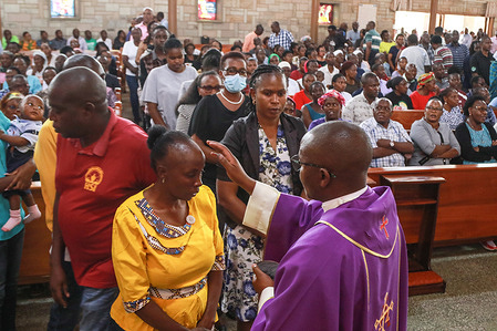 A priest smears a sign of the cross on worshipper’s foreheads during the annual observance of the Ash Wednesday at The Cathedral Church of Christ The King in Nakuru.
