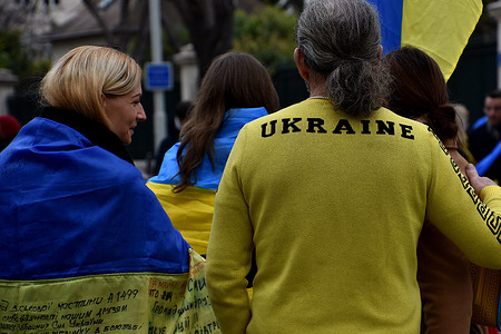 Protesters seen draped with Ukrainian flags and others dressed in Ukrainian colors during the demonstration in front of the Russian consulate in Marseille. Ukrainians from France and their supporters protest the Russian invasion of Ukraine after a year of war.