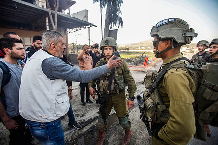 Israeli soldiers separate the Jewish settlers from the Palestinians during the confrontation in Howarah town south of Nablus in the occupied West Bank. Dozens of Israeli settlers went on a violent rampage in the northern West Bank, setting cars and homes on fire after a Palestinian gunman killed two Israeli settlers. Palestinian officials say one man was killed, and four others were badly wounded during the rampage.