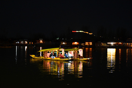 Boatmen ferry Indian tourists on their boats across the world famous Dal lake during a cold winter evening in Srinagar, the summer capital of Jammu and Kashmir.