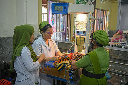 Nurses attend to a sick child suffering from a respiratory disease at Dhaka Shishu hospital. The number of patients in the capital's children's hospital is increasing day by day suffering from various diseases including respiratory diseases.