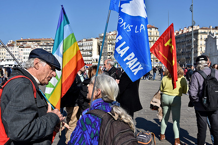 Protesters hold flags during the peace demonstration in Marseille. People demonstrated for peace and against all wars at the Old Port in Marseille.