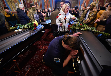 People pay their last respect around the coffins with the bodies of the Ukrainian soldiers Maxim Mikhailov, Yuriy Horovets, Taras Karpyuk and Bohdan Lyagov during the funeral ceremony at the St. Michael Cathedral in Kyiv. On March 7, they said goodbye to the Ukrainian intelligence officers who died while performing a combat mission in the Bryansk region of Russia on December 25, 2022. The bodies of these people were returned to Ukraine on February 22, 2023.