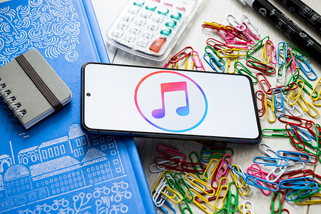 In this photo illustration iTunes logo seen displayed on a smartphone.