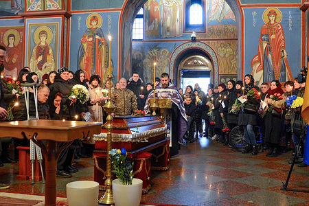 Relatives, friends and servicemen pray next to the coffin with the body of serviceman Oleksiy Sokolovsky during a memorial service at St. Michael's Cathedral in Kyiv. Oleksiy Sokolovsky took part in the hostilities launched by Russia in Donbas back in 2014, when he was wounded during heavy fighting near Donetsk, for which he was awarded the Order of Courage III degree, but after the full-scale invasion of Russia in 2022, he left again to fight Oleksiy died on February 7, 2023 near Bakhmut, where the military of the Russian Federation is currently conducting offensive operations.