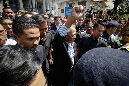 Malaysia's former Prime Minister Muhyiddin Yassin (C) walks out of the Kuala Lumpur courthouse after he was charged of corruption. Muhyiddin Yassin has been charged with four counts of corruption and two charges of money laundering, making him the second former Prime Minister to be accused.