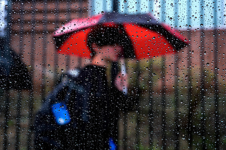 A student with an umbrella leaves Temple City High School in the rain.