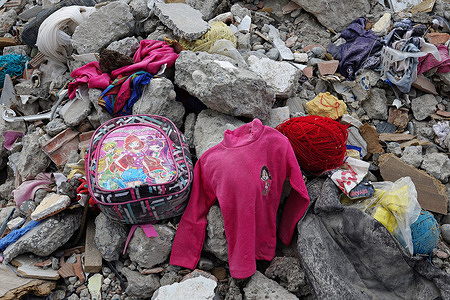 A little girl's school bag, clothes, and red yarn used by her mother to knit are seen left in the rubble of a collapsed building. In the city of Diyarbakir, the debris of buildings destroyed during the earthquakes on February 6 have been cordoned off by local authorities. The total number of deaths in the 7 buildings that collapsed has reached 242.