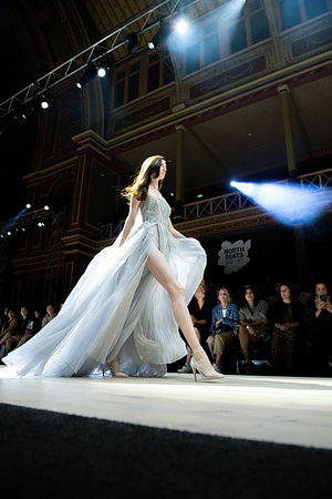 A model walks the runway during Paolo Sebastian fashion show at the Royal Exhibition Building in Melbourne. Celebrating the mastery of Paolo Sebastian's Australian design house, the Melbourne Fashion Festival hosted a solo runway that presented a mix of archival pieces and the new 2022-23 autumn-winter collection, Moonlight Serenade. Attendees witnessed the intricate craftsmanship of founder and designer Paul Vasileff and his team of specialized seamstresses, who brought each piece to life using traditional methods of craftsmanship. The audience was enchanted by the ethereal gowns, each taking between 800 and 1550 hours of hand embroidery, as they paid tribute to long-forgotten romance and modern dreamers in a vintage world.