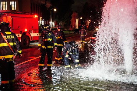 Firefighters work on the fire hydrant. A fire hydrant located at the roadside at Central Ave in Alameda, California was crushed by a car on March 12. The water under the fire hydrant came out and flooded the road. The firefighters of the Alameda Fire Department responded to solve this issue and stopped water from coming out.