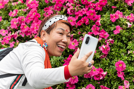 A visitor poses for a selfie at the 2023 Hong Kong Flower Show in Victoria Park. This event is taking place for the first time since 2019, owing to cancellations due to the covid-19 pandemic.