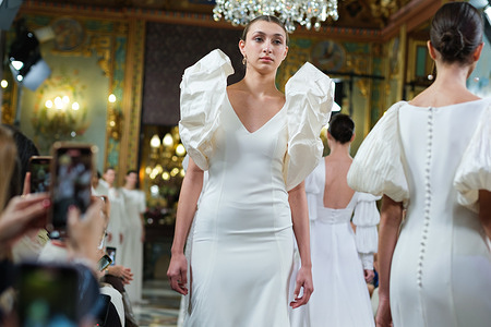 Models showcase creations by AMARCA during the Atelier Couture bridal catwalk within Madrid Fashion Week, held at Santa Isabel Palace in Madrid.
