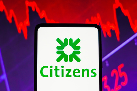 In this photo illustration the Citizens Financial Group logo seen displayed on a smartphone screen, with graphic representation of the stock market in the background.
