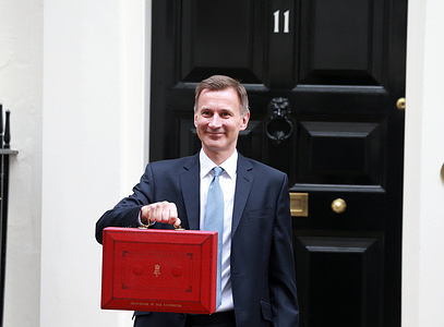 Jeremy Hunt leaves Downing Street with the red budget box to present his spring budget to parliament in London. Chancellor Jeremy Hunt Presents His First Spring Budget.
