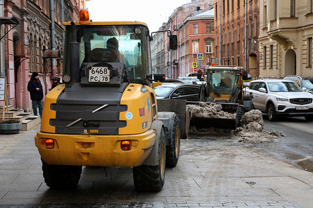 Tractors clear snow off the road in the center of Saint Petersburg.