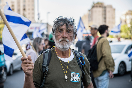 An Israeli reserve soldier holds an Israeli flag during the demonstration. Israeli protesters against the legal overhaul rallied around the country to disturb the public order for the third time.