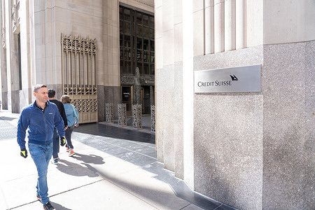 People walk by the building housing the Credit Suisse bank offices on Park Avenue South in Midtown Manhattan in New York City. UBS Nears Acquisition of Credit Suisse Amid Efforts to Stabilize Banking Sector.